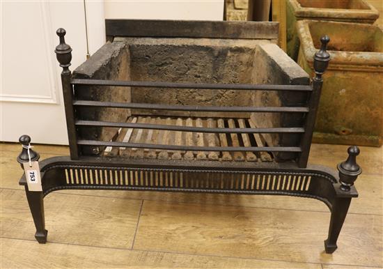 A black painted cast iron fire grate W.77cm